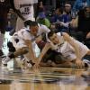 Jake Odum (right) and Dwayne Lathan bang heads as they dive for a loose ball.